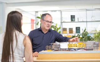 Nick Fairham CEO looking at an architectural model